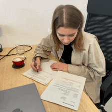 Gif of Julia signing a contract, sitting at a desk