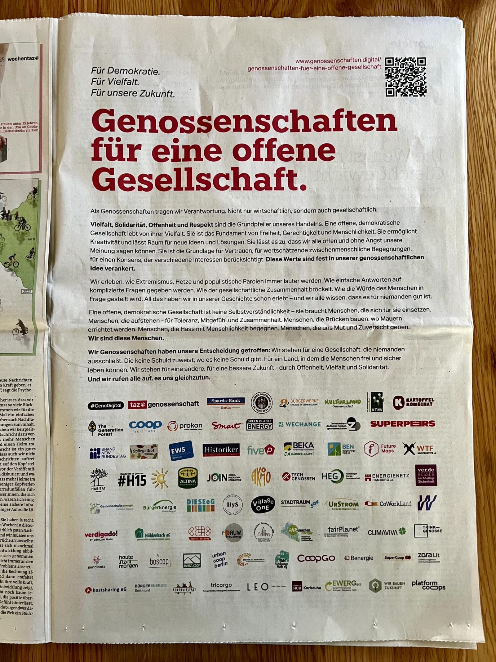 A photo of a full-page ad in a newspaper, under the headline “Genossenschaften für eine offene Gesellschaft”, with 70+ logos of cooperatives who signed the letter